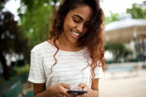 close-up-smiling-young-indian-woman-looking-at-phone-for as a result of local seo strategy